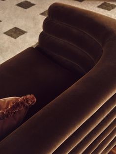 a brown couch sitting on top of a wooden floor