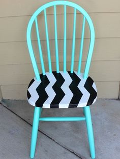 a blue chair with black and white chevrons on the back, sitting in front of a building