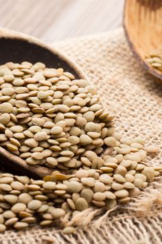 some seeds are in a wooden spoon on a table