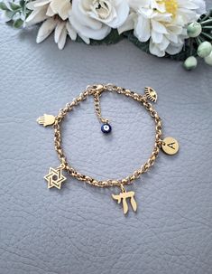 This is our beautiful personalised Jewish Braceler with Chai, Hamsa, Star of David, Lucky Eye and initial letter charms. It Makes a beautiful and thoughtful gift for your loved ones. Materials are 18k gold plated over Stainless Steel, it's hypoallergenic, waterproof and tarnish resistant.   All our items are custom made, it takes 3-5 days to get your order prepared.  The delivery date will depend on your location.  * USA - 2 - 4 weeks * Canada - 2 - 5 weeks * Europe - 2-3 weeks * Other - 2 - 4 w Gold Plated Charm Bracelet For Gift, Gold Bracelet With Charms As A Gift, Symbolic Gold Plated Charms For Gifts, Gold Spiritual Charm Bracelet, Gold Stainless Steel Bracelets As Gift For Her, Gold Stainless Steel Bracelet As Gift For Her, Gold Stainless Steel Bracelets For Her, Gold Stainless Steel Bracelet For Her, Personalized Yellow Gold Metal Bracelets