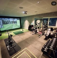 an indoor golf simulator is set up in the middle of a room with exercise equipment