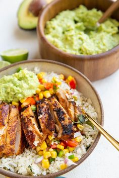 two bowls filled with rice, chicken and vegetables next to guacamole sauce