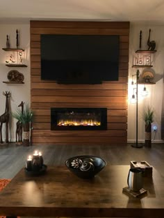 a living room with a fire place and television on top of the wall above it