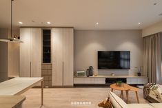 a living room filled with furniture and a flat screen tv mounted on a wall above a wooden coffee table