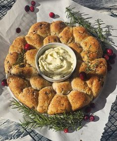 a platter with rolls and cream cheese on it, surrounded by cranberries