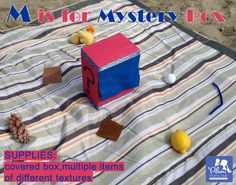 an image of a box on a blanket with other items around it and the words mystery box