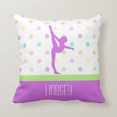 a pillow with a girl doing a handstand on polka dotty dots in purple and green