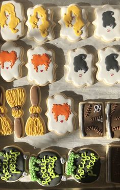 decorated cookies in the shape of women and men are displayed on a baking sheet,