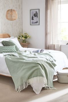 a bedroom with a bed, nightstands and pictures hanging on the wall above it