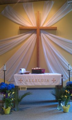 the altar is decorated with blue flowers and white draping, along with a cross