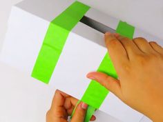 someone is cutting out some green tape from a box