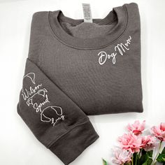 If your mother is a pet lover, this is the product for her! The collar is embroidered with the elegant words "Dog mom" expressing your mother's great love for her pets. The sleeves are cleverly embroidered with the image of her dog's ears, making the shirt cuter than ever. We have different fonts as well as a variety of colors so you can choose one that suits your mom. This dog mom sweatshirt is not only fashionable but also warm. It would be great for your mom to wear this shirt and take her pu Mom Embroidery, Elegant Words, Name Unique, Dog Mom Sweatshirt, Love For Her, Personalized Anniversary Gifts, Embroidered Tee, Dog Ear, Anniversary Gifts For Couples