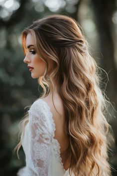 a woman with long hair wearing a wedding dress in the woods, looking off into the distance