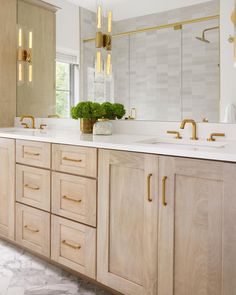 a large bathroom with two sinks and gold fixtures