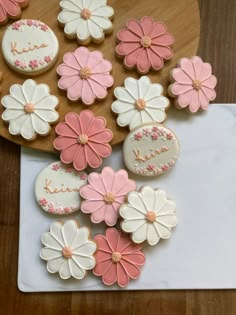 cookies decorated with flowers and the words i love you written on them are sitting on a cutting board