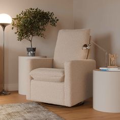 a living room with a chair, lamp and potted plant