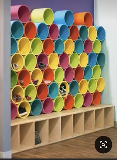 the shelves are filled with different colored plastic cups on them, and there is also a shelf that holds several pairs of shoes