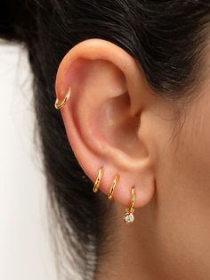 a close up of a person's ear with two small gold rings on it