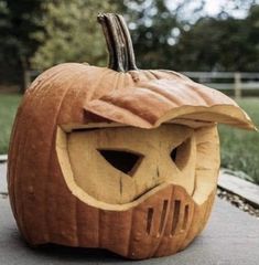 a carved pumpkin sitting on top of a sidewalk