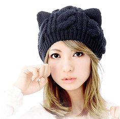 a woman wearing a black cat hat with long bangs and brown eyes is posing for the camera