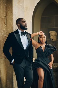 a man in a tuxedo standing next to a woman in a black dress