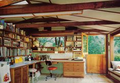 a kitchen with lots of bookshelves and cabinets in the corner, next to a window