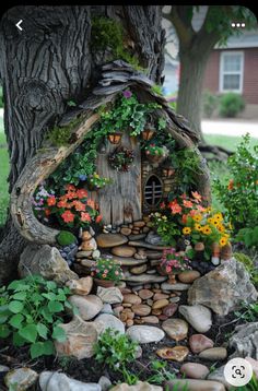 a fairy house made out of rocks and flowers