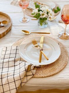 the table is set with gold and white plates, silverware, and napkins