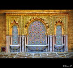 an intricately designed fountain in the middle of a room with tilework on it