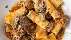 a white bowl filled with pasta and meat