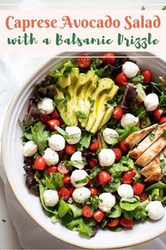 a salad with chicken, avocado and cherry tomatoes in a white bowl on a table