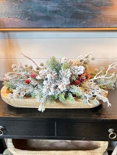 a christmas arrangement on a table in front of a painting