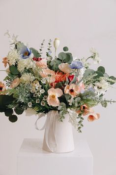 a white vase filled with lots of flowers