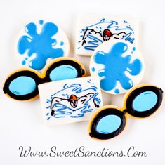 four decorated cookies with blue and black icing