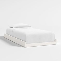 a bed with white sheets and pillows on it