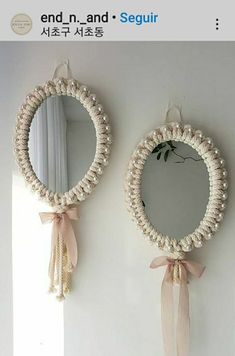 two mirrors hanging on the wall next to each other with ribbons and bows around them