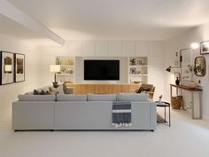 a living room filled with furniture and a flat screen tv mounted on the wall above it