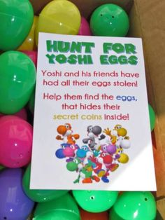 a box filled with lots of colorful eggs next to a sign that says hunt for yoshi eggs