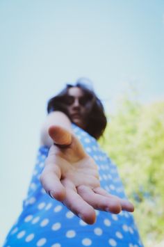 a woman holding out her hand to the camera