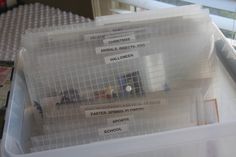 several plastic containers with labels on them sitting in a storage container next to a window