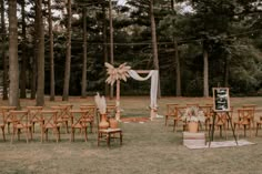 an outdoor wedding set up with wooden chairs