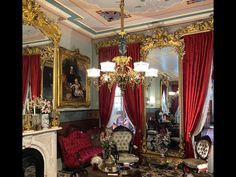 an ornate living room with red curtains and gold trim