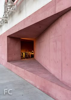 an empty parking garage with clothes hanging in the door and stairs leading up to it