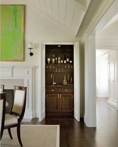 an open door leading into a kitchen with wooden floors and cabinets on the wall above it