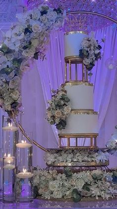 a wedding cake sitting on top of a table next to candles and flowers in vases