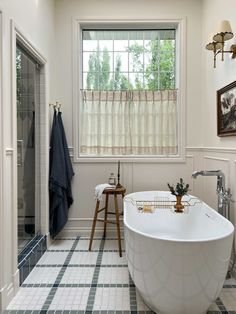 a bath tub sitting next to a window in a bathroom