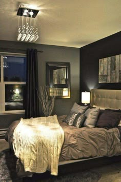 a bed room with a neatly made bed and a chandelier hanging from the ceiling