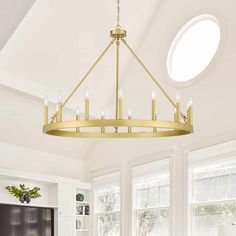 a chandelier hanging from the ceiling in a living room with white walls and windows