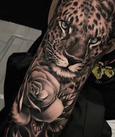 a man with a tattoo on his arm that has a leopard and roses on it