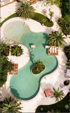 an aerial view of a pool with lounge chairs and palm trees